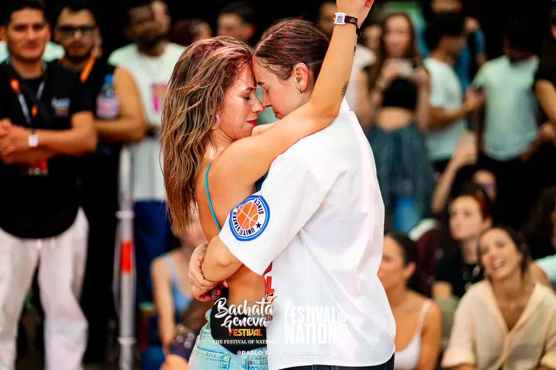 Two dancers in a warm embrace on the edge of the floor